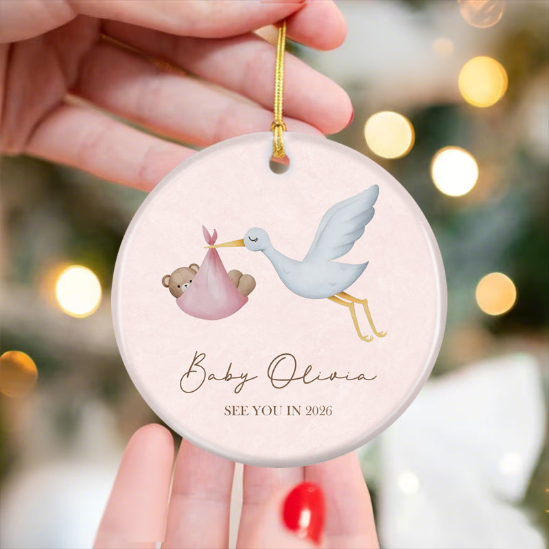 Stork and baby bear ornament for announcing a 2026 baby arrival, customizable with baby’s name. Soft pink aesthetic, a charming keepsake for expecting parents to mark this special milestone.