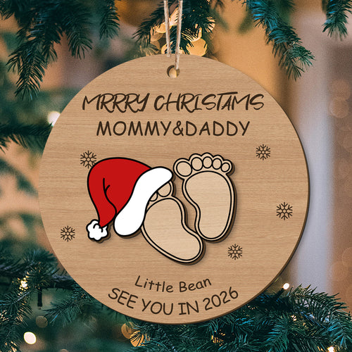 Custom baby footprint Christmas ornament with Santa hat, "Merry Christmas Mommy & Daddy", and "See You in 2026". Perfect personalized holiday keepsake for new parents, customizable with names and year.